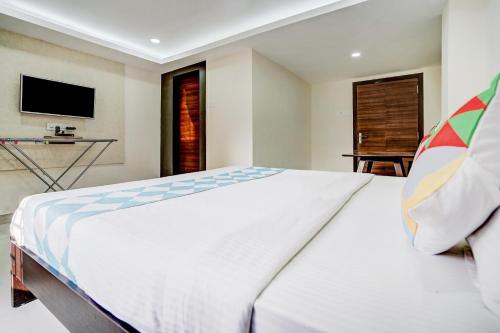 a bedroom with a large white bed and a television at Super Capital O Sayhallo Prime Residency in Bhubaneshwar