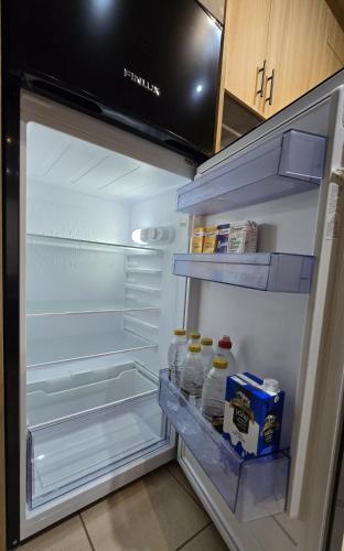 an open refrigerator with milk and eggs in it at GpxClr-Come Undone Suite in Larisa