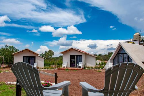 two chairs sitting in front of a house at Cabañas Misión Amealco in Amealco
