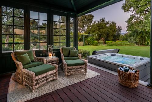 zadaszony ganek z wanną z hydromasażem i krzesłami w obiekcie Foxen Canyon Retreat by Paradise Retreats w mieście Los Olivos