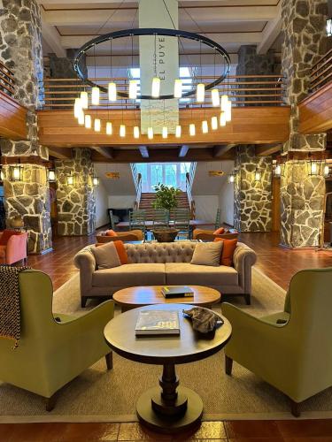 a living room with a couch and a table and chairs at Hotel Termas Puyehue Wellness & Spa Resort in Puyehue