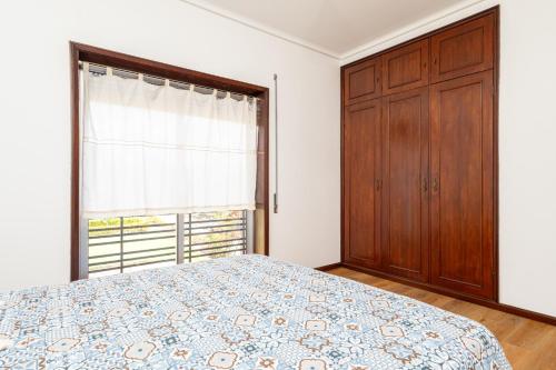 a bedroom with a bed and a large window at Pontesmar in Esmoriz