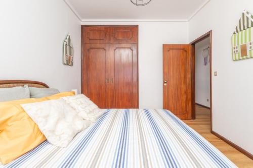 a bedroom with a bed and a wooden door at Pontesmar in Esmoriz