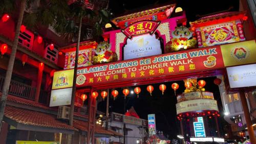 a building with neon signs in a city at night at Holiday Inn Melaka by IHG in Melaka