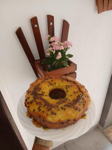 a large bagel sitting on a plate next to a chair at Pouso C&L in Tiradentes