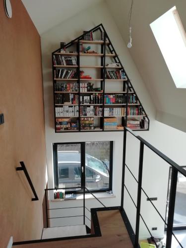 a spiral staircase with a book shelf in a house at Luxury eco home with large garden and lots of light in Sas van Gent