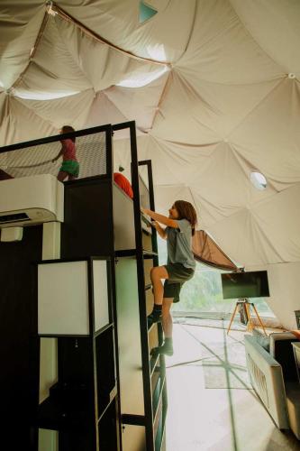 two girls are climbing up a ladder in a tent at 2 domes in Glendale Utah Fantastic Stargazing in Glendale