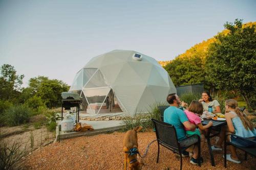 a group of people sitting at a table in front of a tent at 2 domes in Glendale Utah Fantastic Stargazing in Glendale