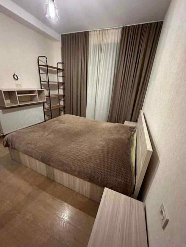 a bedroom with a large bed and a window at bakuriani in Itʼkhvisi