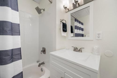 a white bathroom with a sink and a mirror at The Beachside in Sylvan Beach