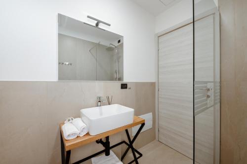 a white bathroom with a sink and a shower at Independent Rooms in Verona