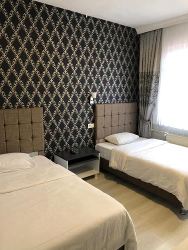 a hotel room with two beds and a window at GOLD SARAY PANSİYOn in Saray
