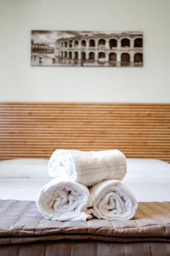 a pile of towels sitting on top of a bed at Independent Rooms in Verona