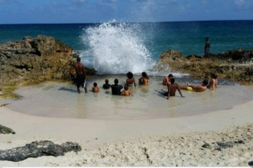 a group of people sitting in the water on a beach at Aguasoleil in Saint-François
