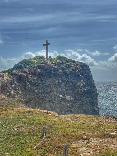 a cross on top of a hill with the ocean at Aguasoleil in Saint-François