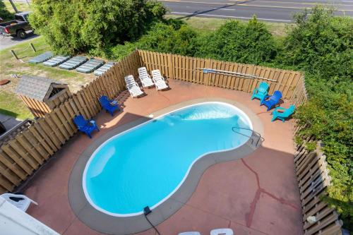 an overhead view of a swimming pool with chairs and a fence at 5115 - Salt Therapy in Kill Devil Hills