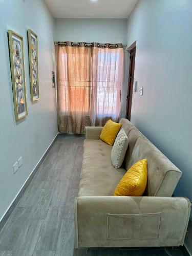 ein Wohnzimmer mit einem Sofa und gelben Kissen in der Unterkunft Tu escapada perfecta in Mazatlán
