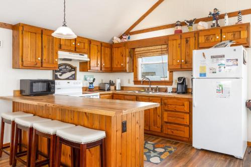 a kitchen with wooden cabinets and a white refrigerator at 7097 - Kickin` Back in Nags Head