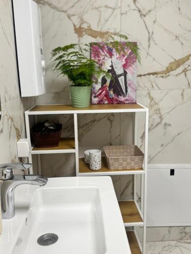 a white shelf with a painting on it next to a sink at Grand Lake View Apartment in Ohrid