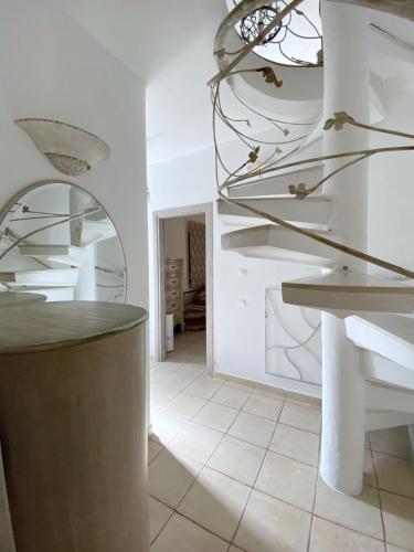 a white room with a counter and a staircase at Hébergement cycladique - près de Panormos in Mykonos