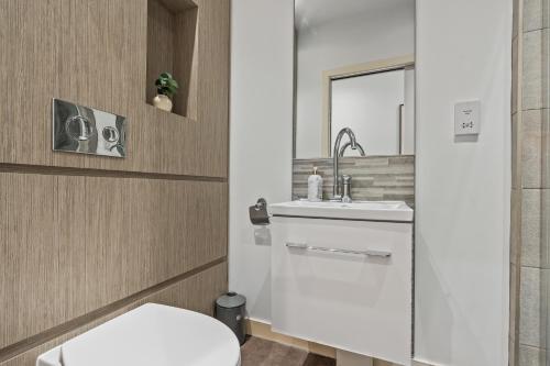a bathroom with a white toilet and a sink at Spacious Central Leeds Flat - Sleeps 8 - City Centre in Central Station