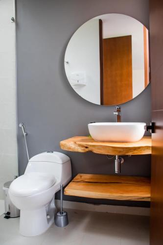a bathroom with a white toilet and a mirror at La Dolce Vita, Guatavita in Guasca