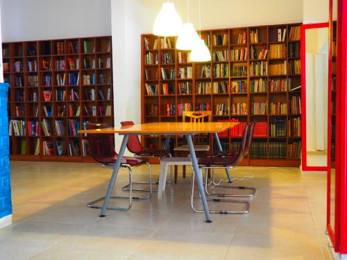 a library with a table and chairs in front of book shelves at Atlas Apart Hotel in Cesme