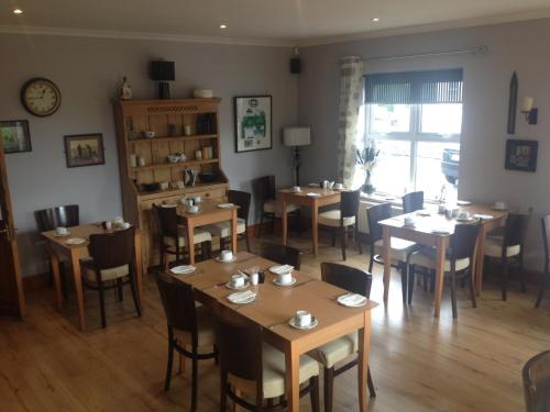 een restaurant met tafels en stoelen in een kamer bij Carragh House in Castlebar