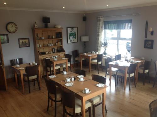 a restaurant with tables and chairs in a room at Carragh House in Castlebar