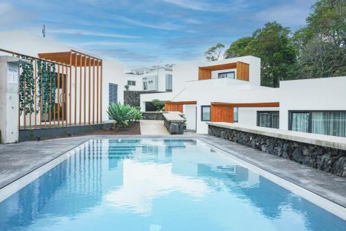 an image of a swimming pool in front of a house at Vilas do Olival in Ponta Delgada
