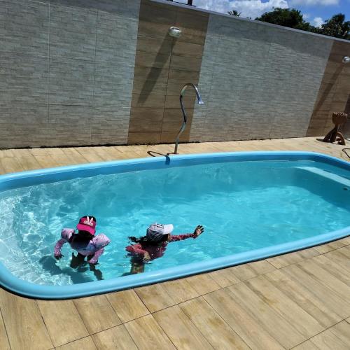 two people in the water in a swimming pool at Casa da Preguiça in Nova Viçosa
