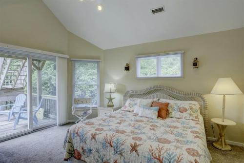 a bedroom with a bed and a balcony at 2012 - Grateful Duck in Duck