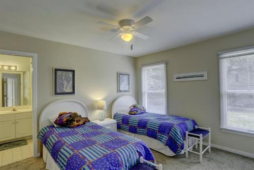 a bedroom with two beds and a dog laying on the bed at 2012 - Grateful Duck in Duck