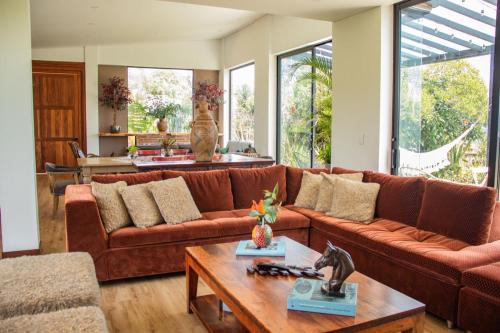 a living room with a brown couch and a table at La Dolce Vita, Guatavita in Guasca