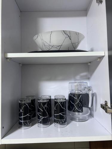 four glass jars and a bowl on a shelf at Luxury apartment new giza Compound in Abū Rawwāsh