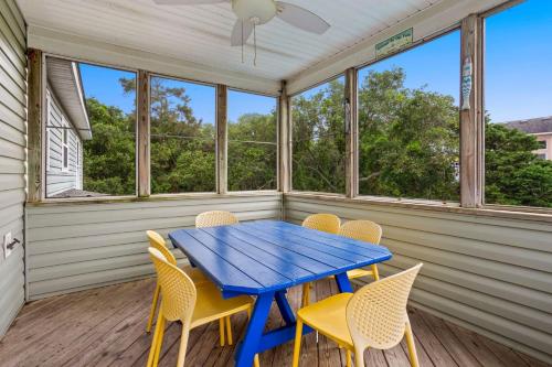 a dining room with a blue table and chairs at 2000 - Pipers Paradise in Duck