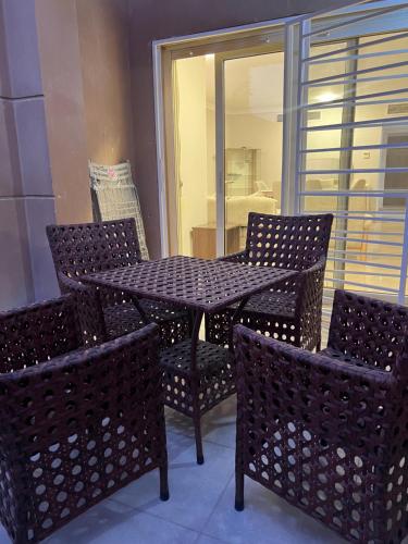 a table and chairs with a table and a window at Luxury apartment new giza Compound in Abū Rawwāsh