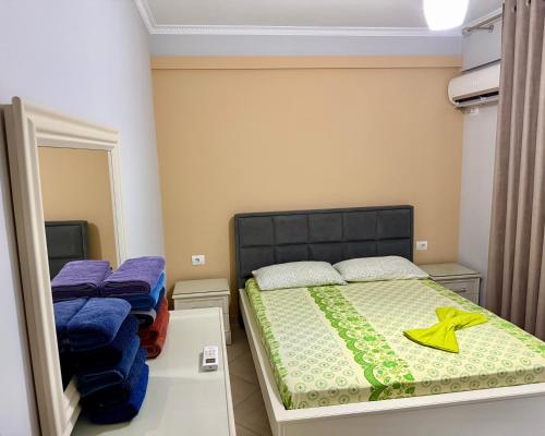 a small bedroom with a bed and a mirror at Queen Ekaterina II in Vlorë