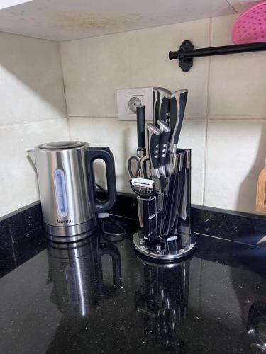 a kitchen counter with a coffee pot and utensils at Luxury apartment new giza Compound in Abū Rawwāsh