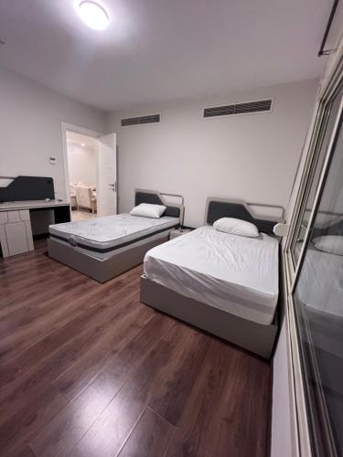 a bedroom with two beds and a desk and a television at Luxury apartment new giza Compound in Abū Rawwāsh