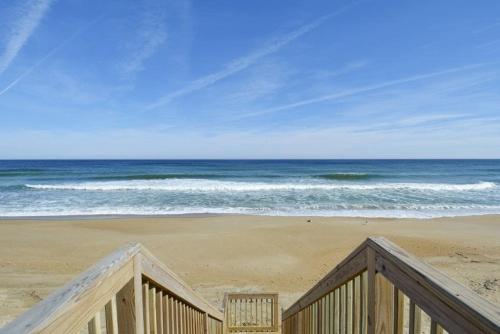 a view of the ocean from a wooden railing on a beach at SO5A - Oceanside Bungalow in Kill Devil Hills