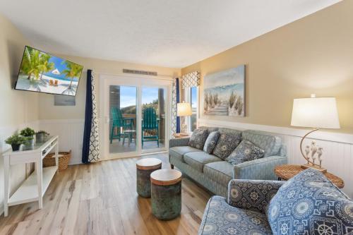 a living room with a couch and a table at SO5A - Oceanside Bungalow in Kill Devil Hills