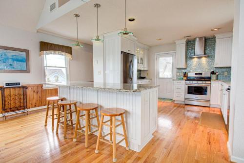 a kitchen with white cabinets and bar stools at 6154 - Little Sushi in Nags Head