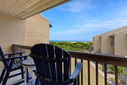 a balcony with chairs and a table and a view of the ocean at QCB5 - Saltaire Sunrise in Nags Head