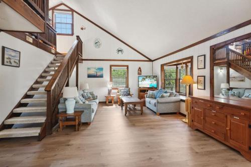a living room with a staircase in a house at 2029 - Duck Yeah in Duck