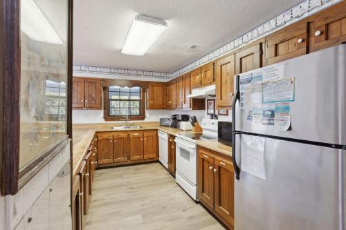 a kitchen with wooden cabinets and a white refrigerator at 2029 - Duck Yeah in Duck