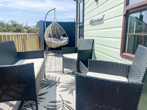 a patio with chairs and a swing on a house at Sunnyside Lodge in Monreith