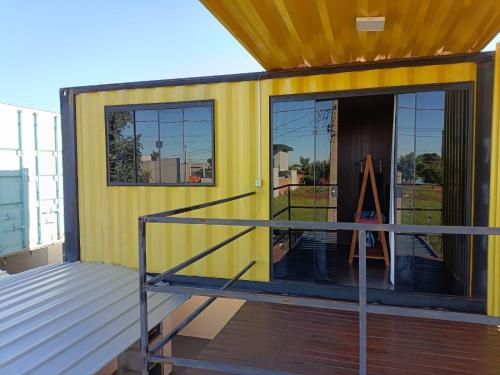 a small yellow house with a glass door at sobrando aconchegante e privado in Dourados