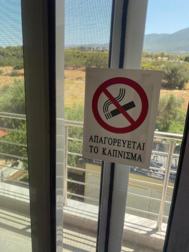 a no smoking sign on a window in a building at Sunset Villa Apartments Alepokhori in Káto Alepokhórion