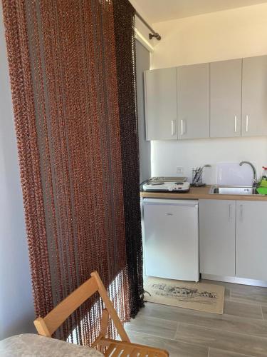 a kitchen with a shower curtain and a sink at Sunset Villa Apartments Alepokhori in Káto Alepokhórion